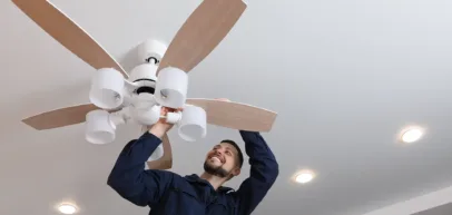 Electrician installing a ceiling fan in a home in Eureka Springs