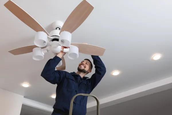 Electrician installing a ceiling fan in a home in Eureka Springs